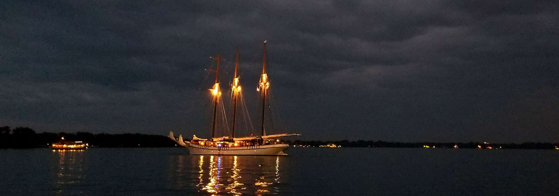 شبی ابری و قایقی با چراغ‌هایش